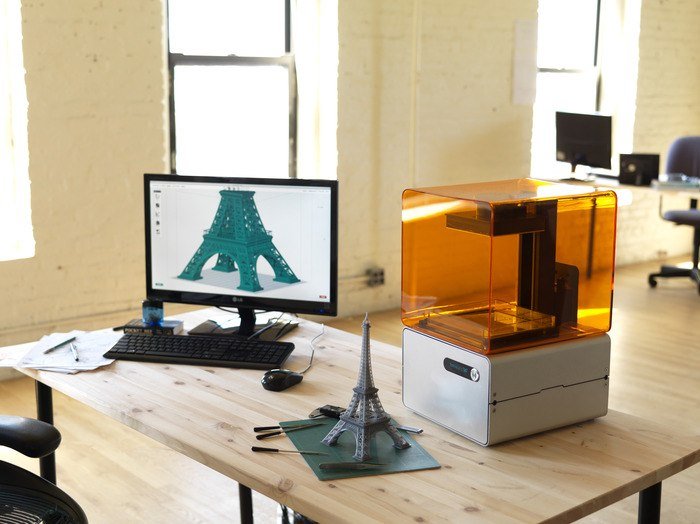 A 3D Printer on a desk with a computer and a 3D printed Eiffel Tower - HeadStuff.org