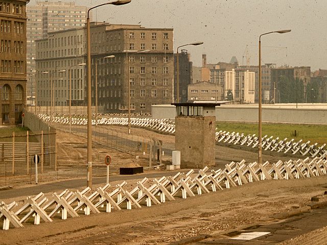 The “death strip” on the East Berlin side of the Wall, with anti-tank “Czech Hedgehog” barriers and a guard tower, fall of berlin wall - HeadStuff.org