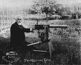 Hiram Maxim in a publicity photo with one of the later models of the Maxim gun, weapon of death, killed millions, bad people in history - HeadStuff.org