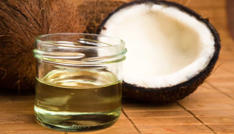 Image of jar of coconut oil beside half a coconut, one of the symbols of the clean eating movement.