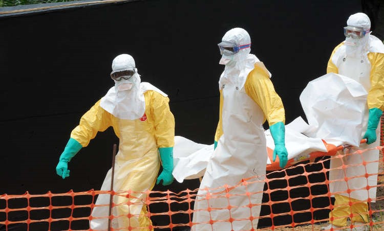 Medicine Sans Frontiers (MSF) doctors remove the body of a person killed by the Ebola virus - HeadStuff.org